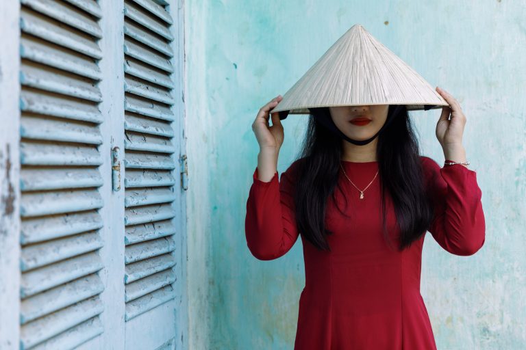 A young Vietnamese woman wearing the traditional Ao Dai dress in Hoi An, Vietnam.