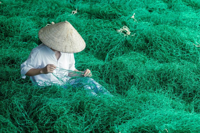 A young woman mending fishing nets in Vietnam. Taken during my Vietnam photo tour.