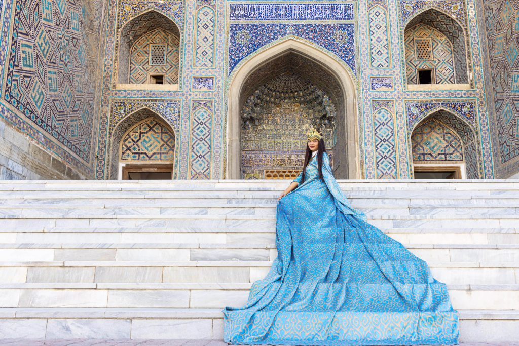 A beautiful young Uzbek woman wearing traditional dress on Registan Square in Samarkand, Uzbekistan.