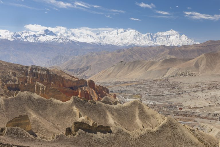 Looking over the wild and desolate landscape of Upper Mustang in Nepal to the Nilgiri Himal mountain range. Part of the Annapurna massif, Nilgiri Himal is composed of three peaks with the highest standing at 7061m.