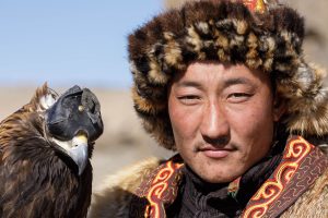 A Kazak Mongolian eagle hunter and his eagle in the Altai near to Bayan Olgii, Mongolia.